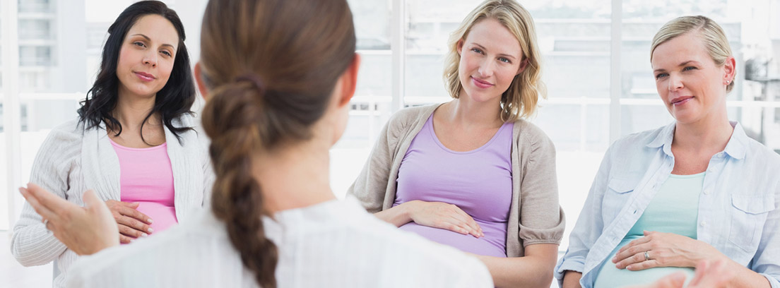 doula conversando con tres mujeres embarazadas