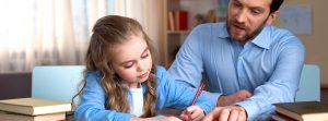 padre ayudando a su hija a hacer los deberes