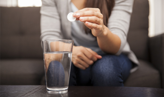 Mujer tomándose una pastilla para el ardor