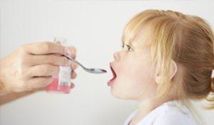 Madre dando a su hija la medicina