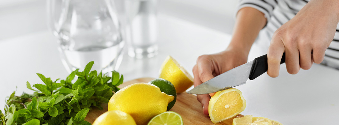 mujer partiendo limones en la cocina