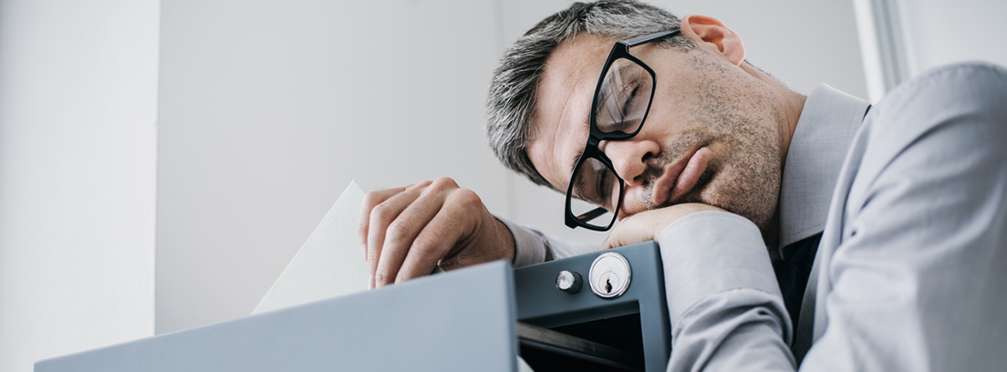 hombre dormido encima de un archivador