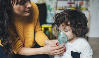 Enfermera poniendo una mascarilla a un niño.