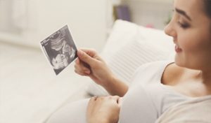 Mujer embarazada mirando la ecografía de su bebé.