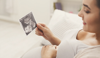 Mujer embarazada mirando la ecografía de su bebé.