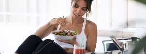 mujer joven comiendo sola en la cocina