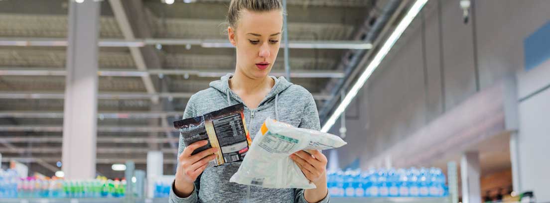 Nuevas tendencias en alimentación: chica mirando productos procesados en un supermercado
