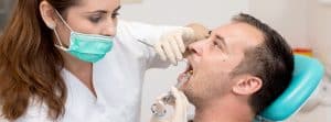 Tipos de anestesia bucodental: dentista poniendo anestesia bucal a paciente