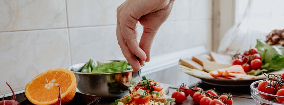 Alimentación saludable durante el confinamiento en casa: hombre preparando una comida de vegetales