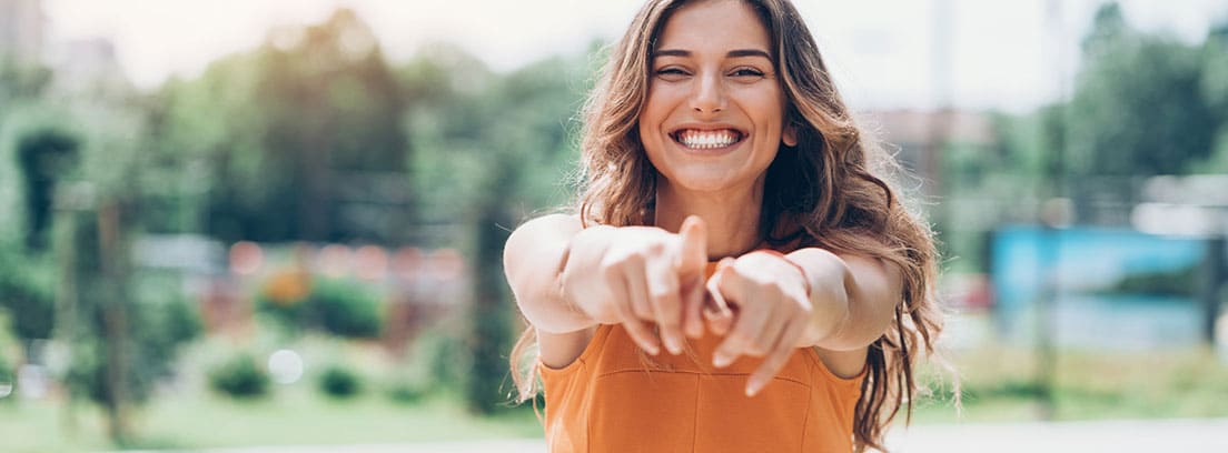 Positivismo vacío: chica joven sonriendo con los brazos extendidos