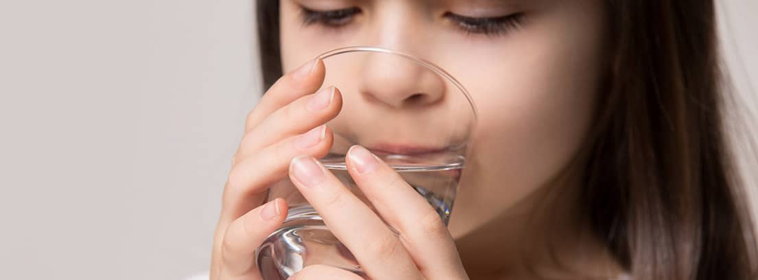 Suero oral para combatir la deshidratación en niños : niña bebiendo un baso con suero