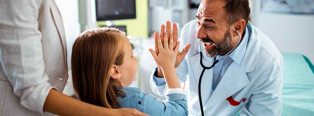 niña chocando manos con medico sonriendo