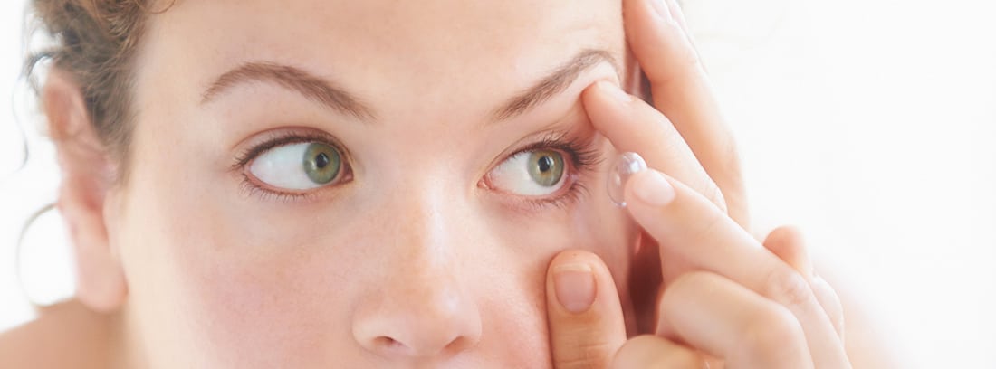 ¿Cómo usar lentes de contacto?: mujer poniéndose unas lentillas
