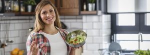 Mujer embarazada enseñando una ensalada