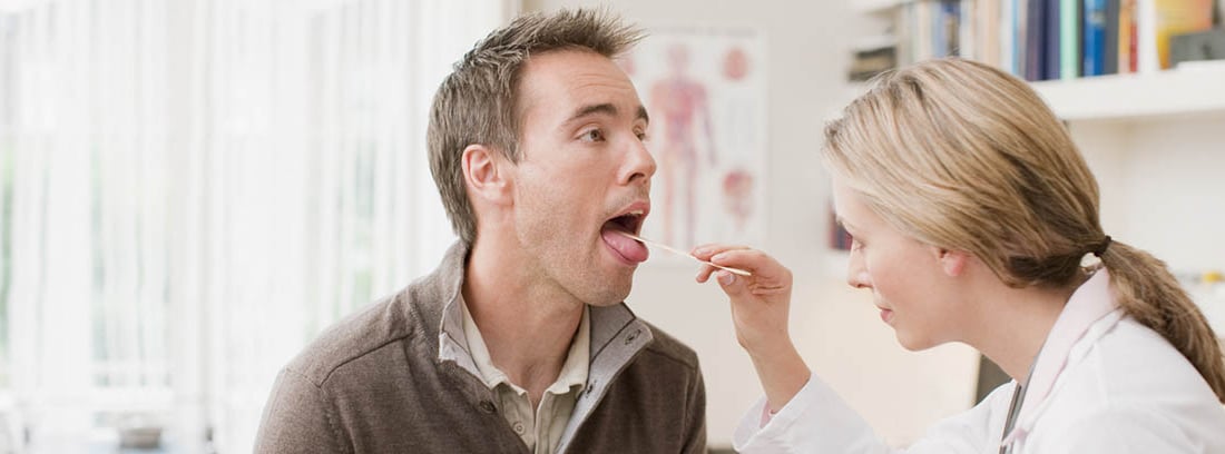 ¿Tienes la lengua blanca? Médico revisando la lengua a un paciente