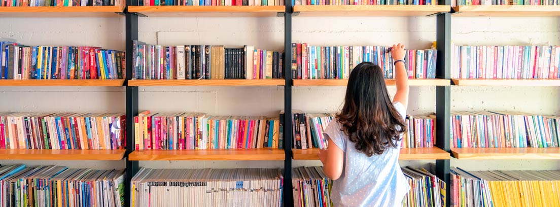 9 Beneficios de la lectura en la salud : chica de espaldas ante una estantería llena de libros