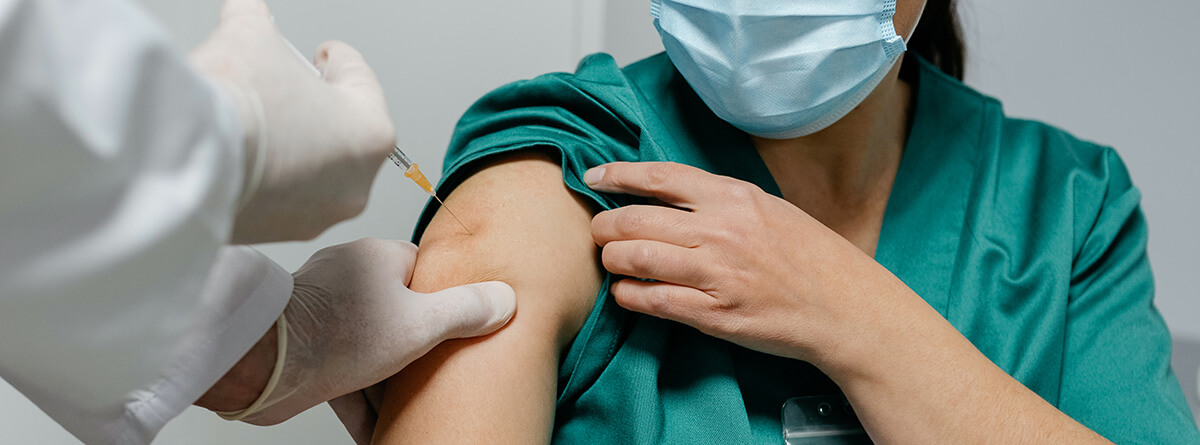 Vacunas frente al COVID: especialista médico vacunando a paciente