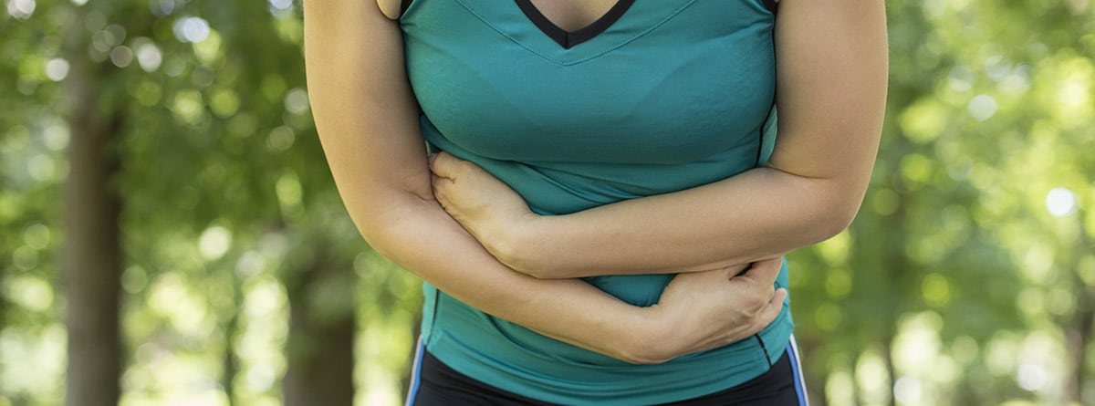 Enfermar antes de una maratón: mujer deportista con problemas de estómago