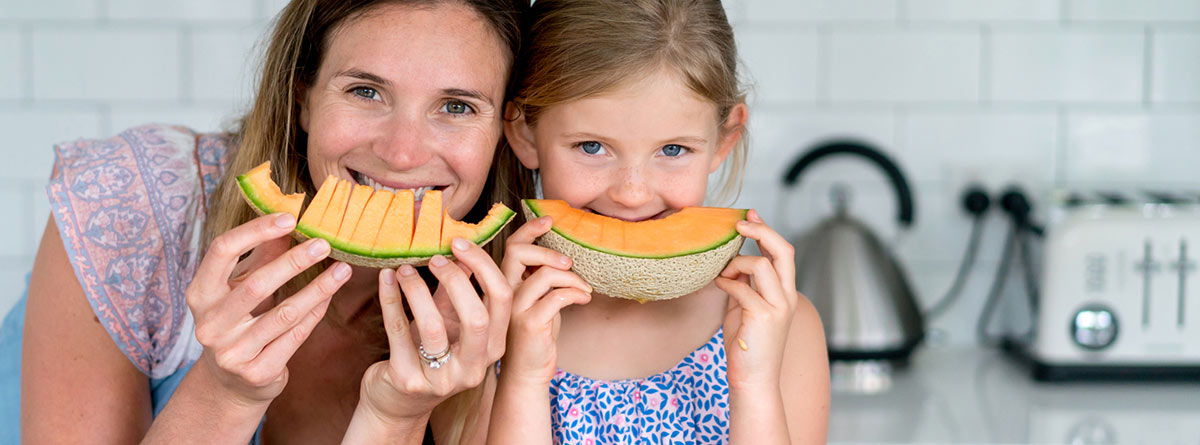 Meón: madre e hija comiendo una raja de melón