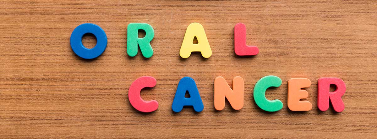 Prevención del cáncer oral: Palabra colorida de cáncer oral sobre fondo de madera