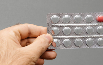 Estudios sobre la píldora masculina: manos sujetando un envase de píldoras