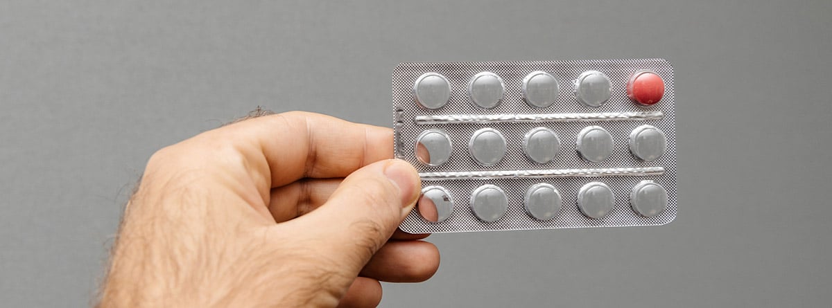 Estudios sobre la píldora masculina: manos sujetando un envase de píldoras