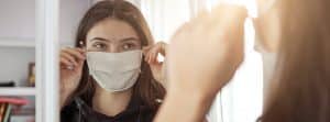 Síndrome de la cara vacía: chica joven con mascarilla ante un espejo