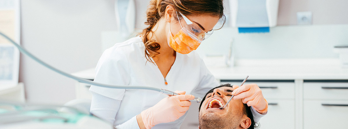 Dientes en el paladar: paciente tumbado en sillón de dentista y odontóloga revisando la boca