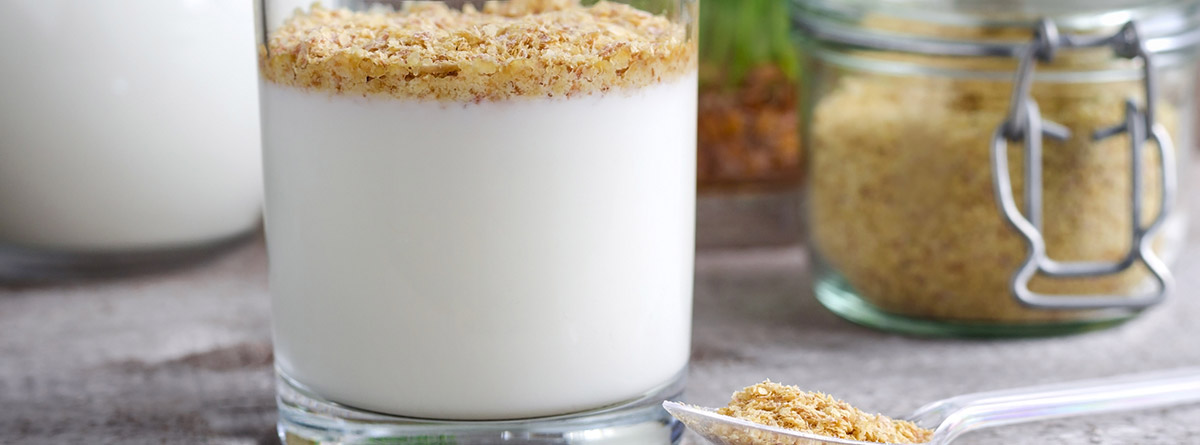 Germen de trigo: vaso de yogur con copos de germen de trigo y bote de cristal 