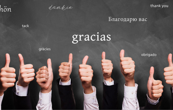 La gratitud, beneficiosa para la salud: puños arriba con un dedo levantado y la palabra gracias escrita sobre fondo gris