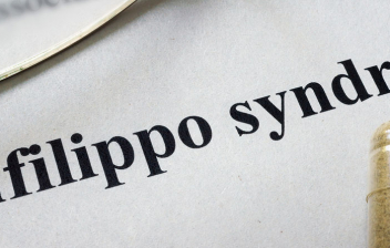 Síndrome de San Filippo: hoja de papel con la palabra síndrome de san Filippo en inglés y unas gafas al lado