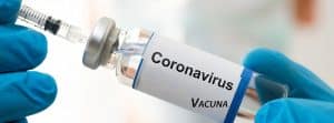 Tercera dosis de la vacuna: manos cogiendo un vial de la vacuna contra el coronavirus