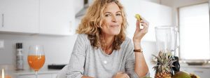 Alimentación para diferentes grupos de población: mujer madura comiendo un trozo de manzana