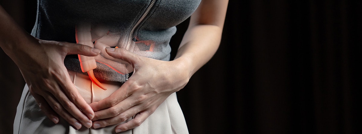 Apendicitis: mujer con las manos en el abdomen y el apéndice sobre ella