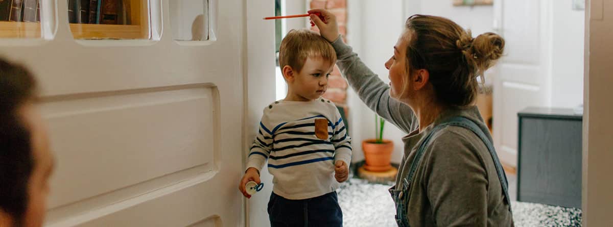 Desarrollo físico del niño de 18 a 24 meses: madre midiendo el crecimiento del niño