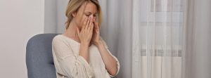 ¿Por qué tengo dolor en el tabique nasal?: mujer joven rubia con las manos en la nariz