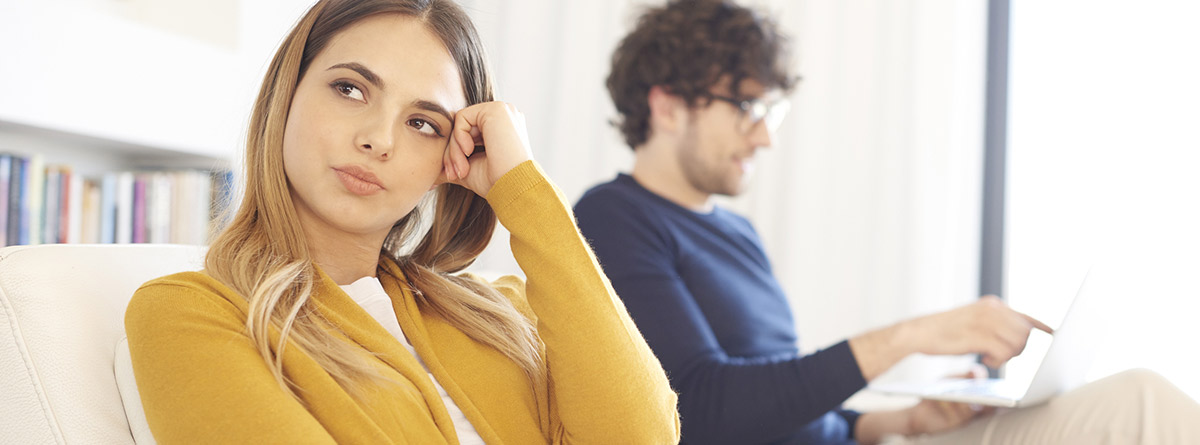 La envidia: chica mirando al lado contrario de chico sentados en un sofá