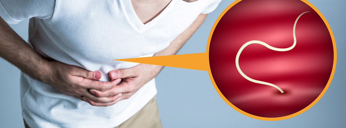 Parásitos intestinales: hombre curvado con loas manos en el estómago y una lombriz dentro de un círculo