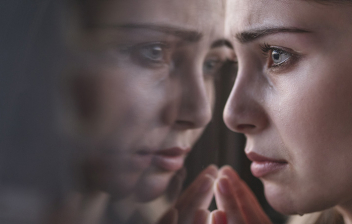 ¿Cómo superar el sentimiento de rechazo?: mujer triste mirando por la ventana