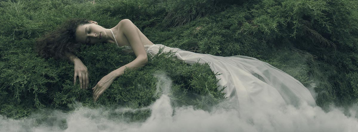 Fases y ciclos del sueño: mujer dormida sobre hierba con nubes alrededor