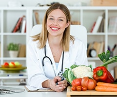 Diferencia entre alimentación y nutrición: mujer nutricionista con una tabla de alimentos saludable