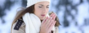 ¿Por qué se tienen las manos frías?: chica joven en la nieve frotándose las manos