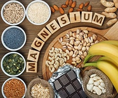 ¿Qué alimentos son ricos en magnesio? variedad de alimentos y cubos de madera con la palabra magnesio
