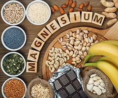 ¿Qué alimentos son ricos en magnesio? variedad de alimentos y cubos de madera con la palabra magnesio