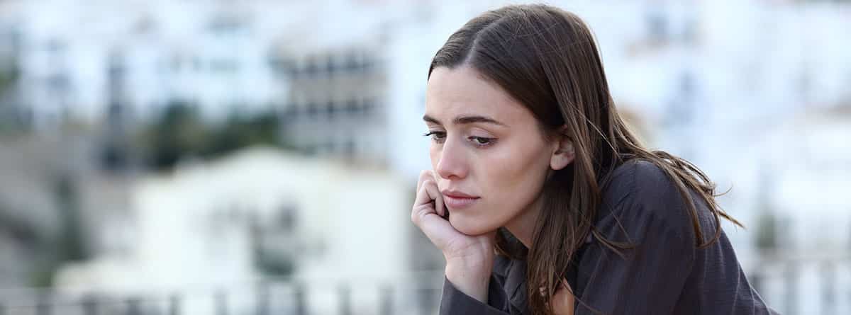 Ecoansiedad ¿qué es y cómo gestionarla?: joven mujer triste mirando por la ventana