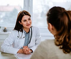 ¿Cuáles son las especialidades de la Psicología?: psicóloga en consulta con paciente mujer joven