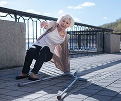 Cómo superar el Síndrome Post-Caída: mujer anciana sufriendo una caída y las muletas al lado
