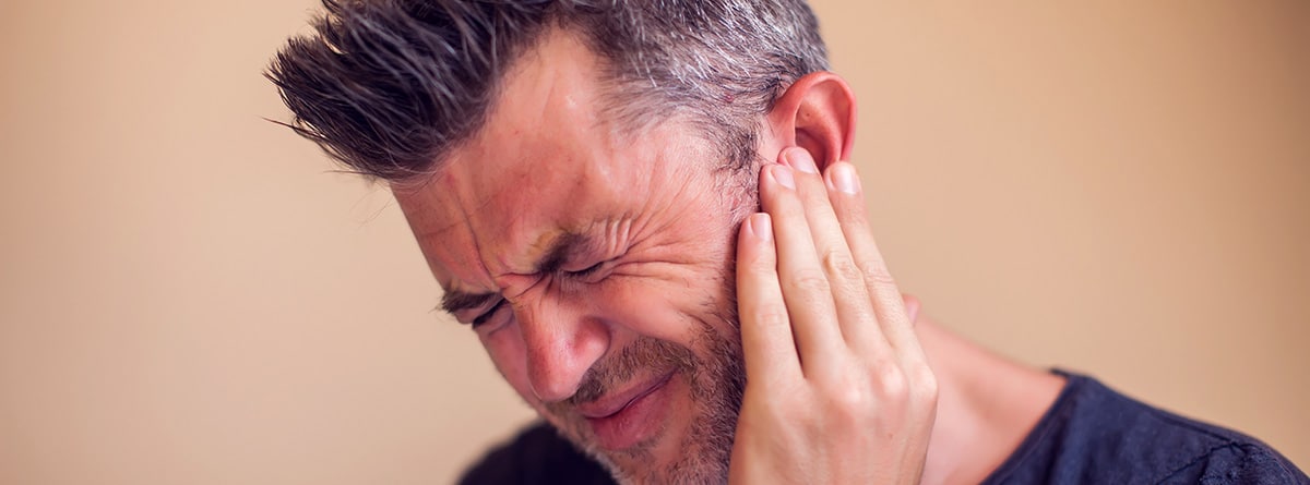 hombre con fuerte dolor en el oído