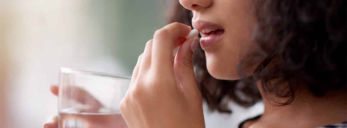 mujer joven tomando pildora