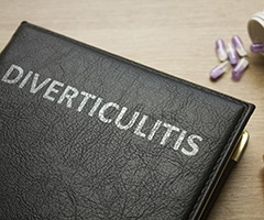 ¿Cuáles son los síntomas de diverticulitis?: libro con las pastas en piel negra y escrita la palabra diverticulitis